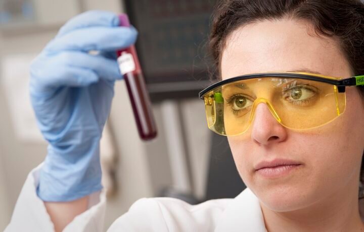 Investigadora examina una muestra de sangre. Imagen ilustrativa de laboratorio; no identifica una prueba de PSA ni un paciente con cáncer de próstata. No corresponde a Misiones.