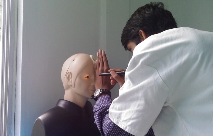 Práctica de examen ocular sobre un maniquí. Imagen ilustrativa de formación clínica; no corresponde a una residencia del Madariaga.
