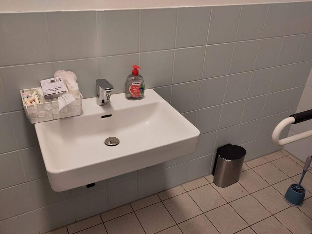Productos de gestión menstrual disponibles en un baño escolar accesible de Berlín, Alemania. Fotografía ilustrativa; no acredita implementación del proyecto misionero.
